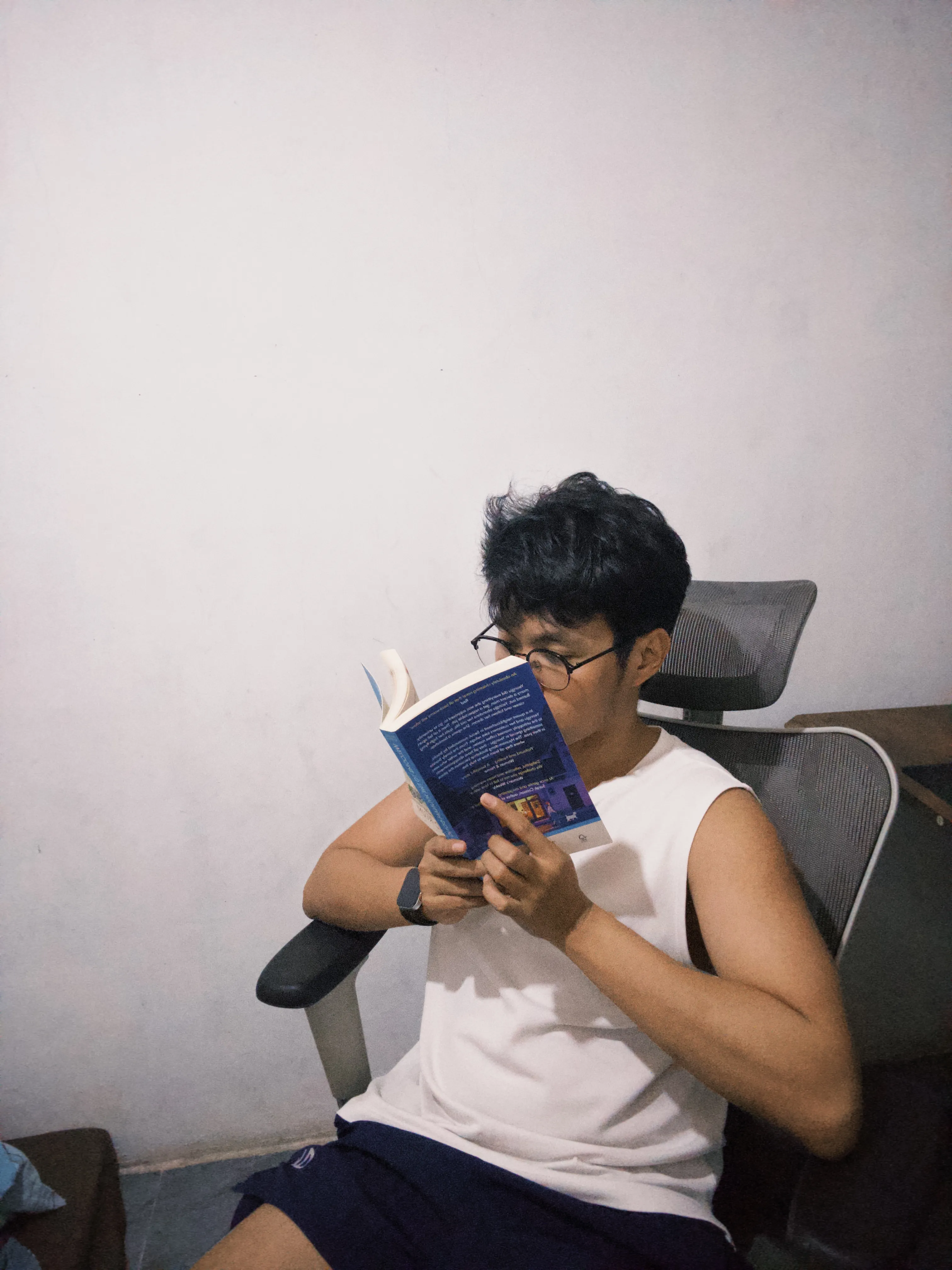 Ericson reading a book beside his desk